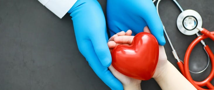 医生握着病人的手，红色的心脏和听诊器
