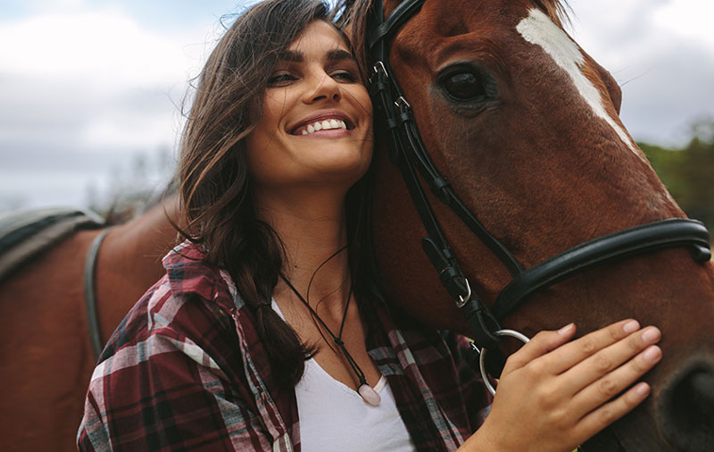 微笑的女子拥抱马
