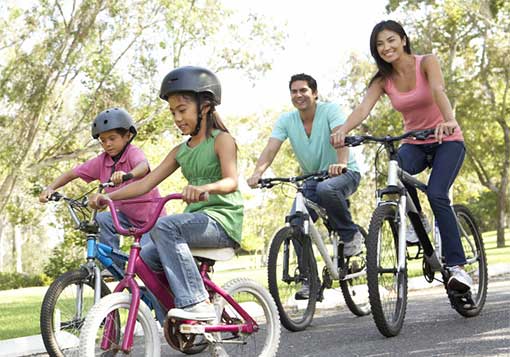 爸爸妈妈带着年幼的女儿和儿子骑自行车