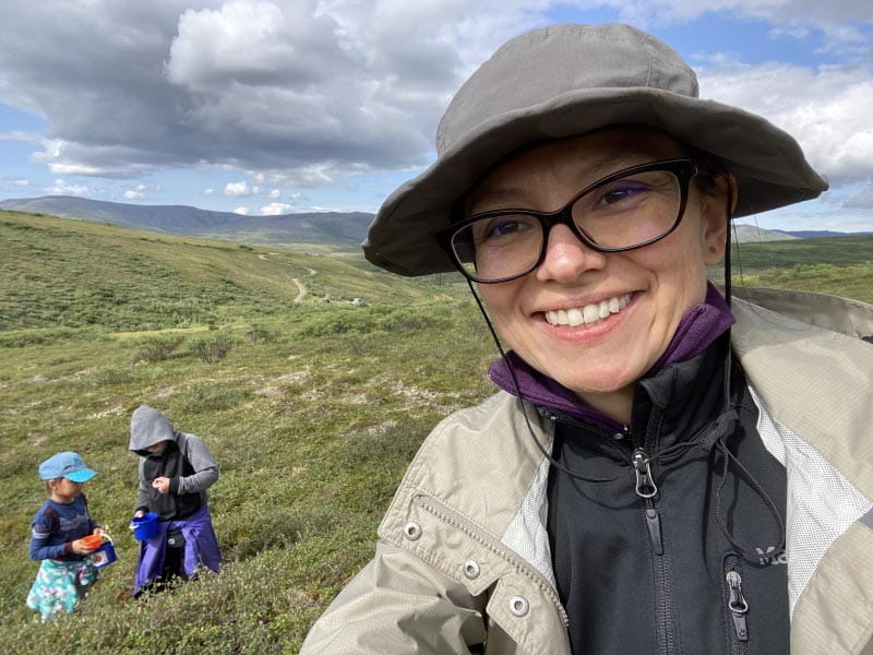 埃里森博士Kelliher(前景)摘浆果on a tundra outside of Nome, Alaska, with her niece Kyra Kelliher and nephew Hanley Kelliher. (Photo courtesy of Dr. Allison Kelliher)