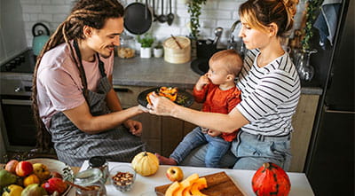 dad and baby and mom eating in kitchen