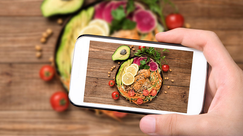 手采取手机的手机照片健康脂肪在沙拉