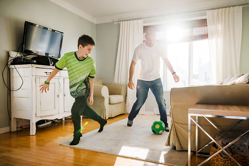 爸爸和儿子在家里踢室内足球
