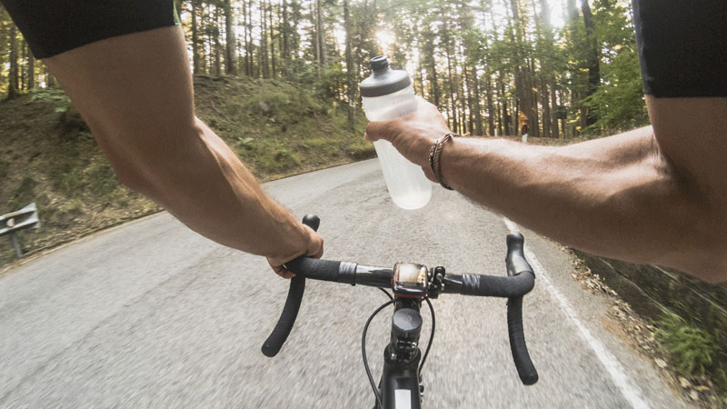 骑自行车的人用水壶喝水