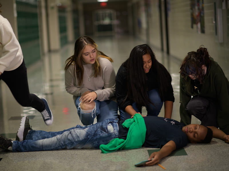 学生们跪在倒下的学生面前