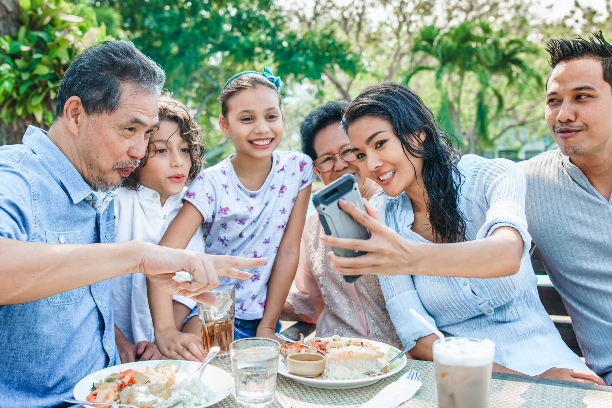 亚裔美国家庭与孩子、父母和祖父母坐在餐桌旁自拍