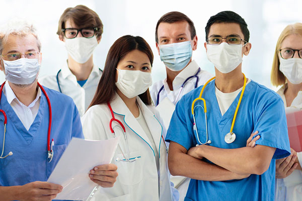 几名医护人员戴着口罩，面对镜头站在一起。