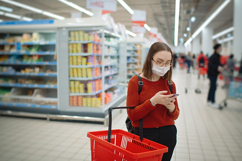女人购物者在购物时读取心脏检查认证的产品列表