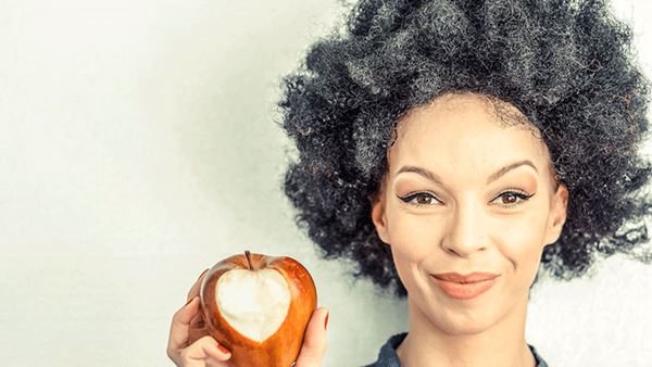 头发花白的女人吃着心形的苹果