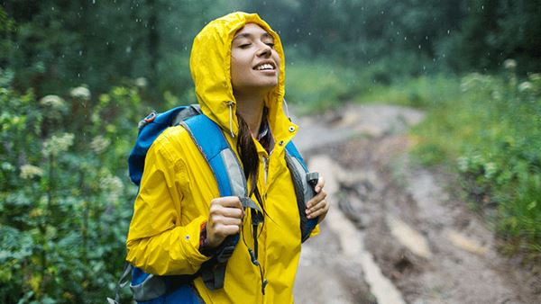 穿着雨衣的年轻女子在雨中享受大自然